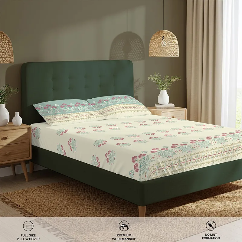 Angled room view of off-white and pink floral fitted bedsheet on a green bed