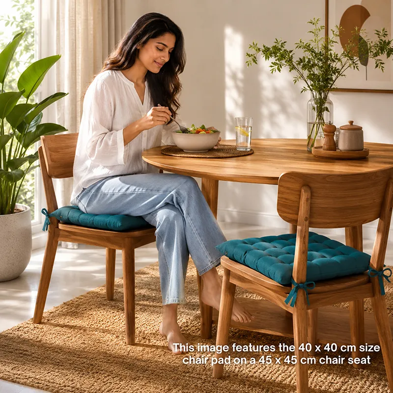 Teal chair pads styled on wooden dining chairs around a dining table.