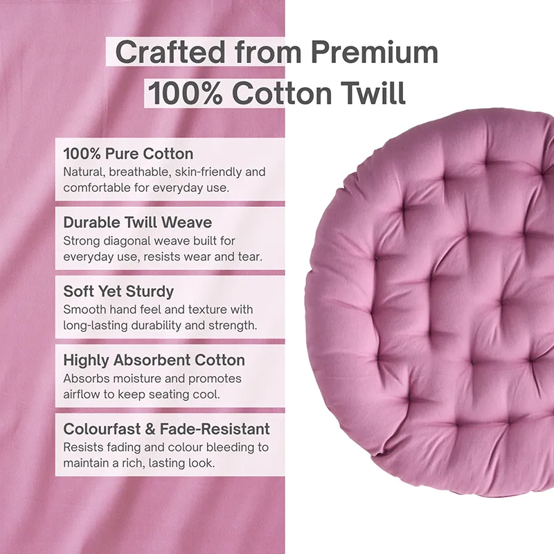 Close-up of a round lilac tufted floor cushion against a plain background.
