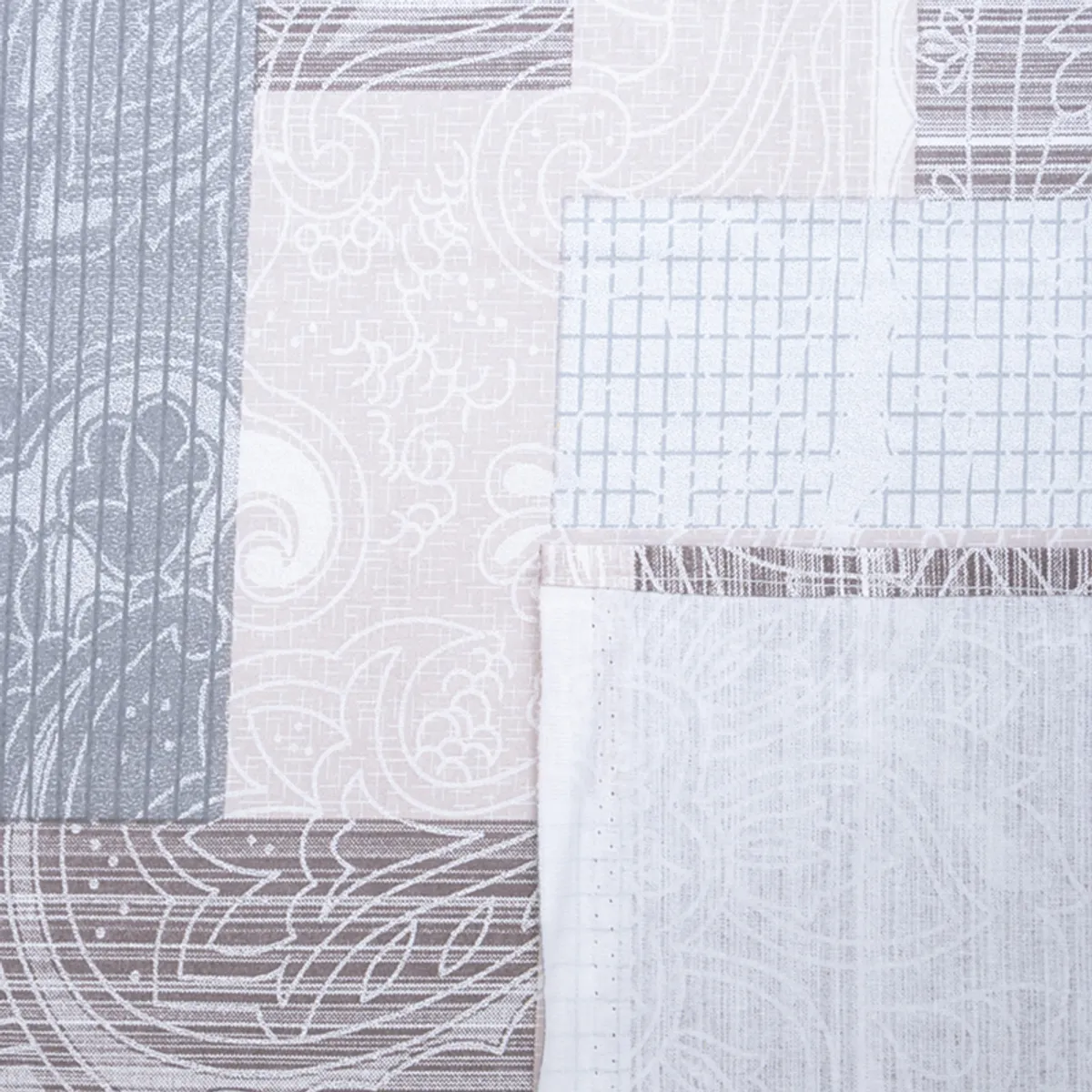 Close-up of the bedsheet corner with geometric patchwork-style print in grey and beige