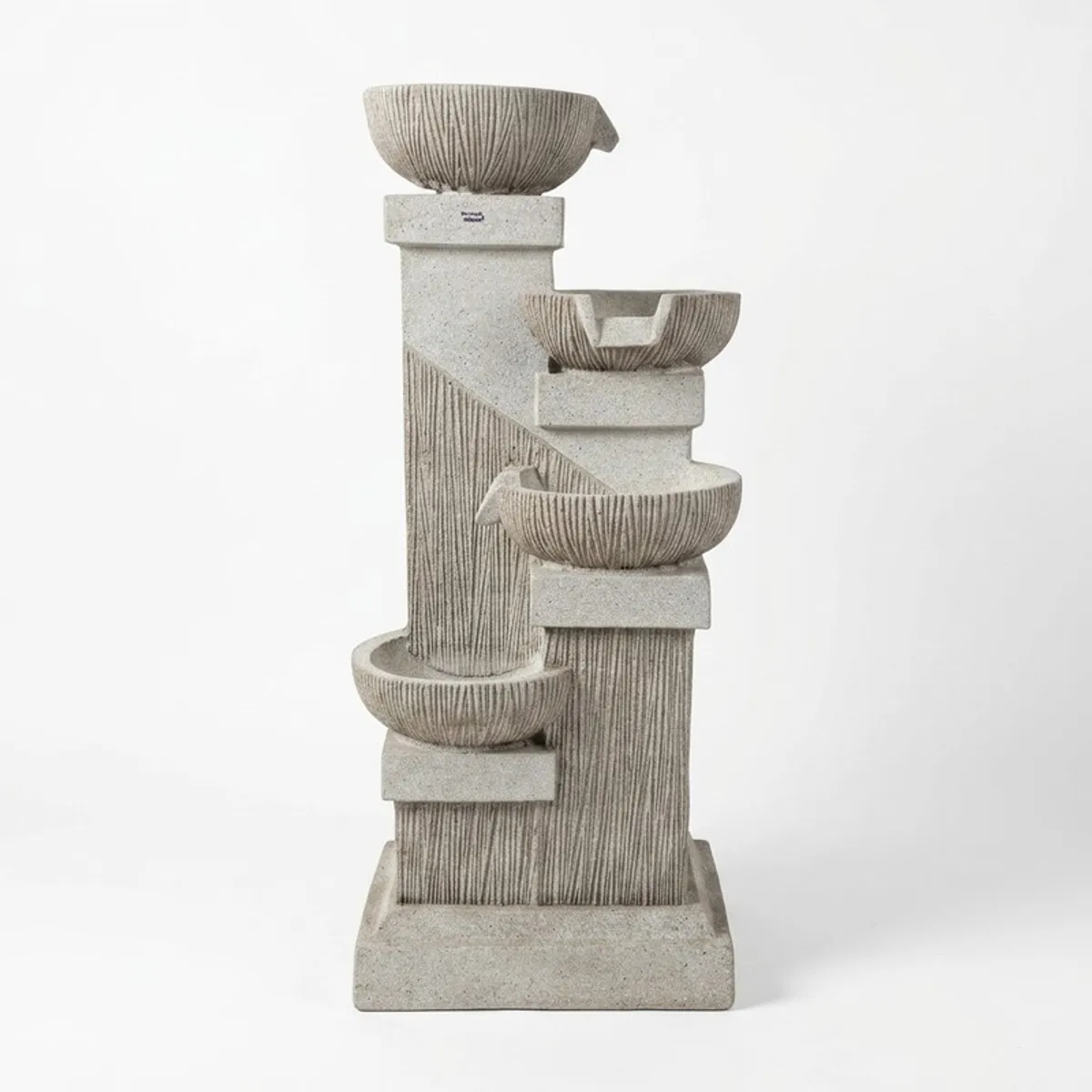 Beige and white multi-bowl tabletop fountain against a white background