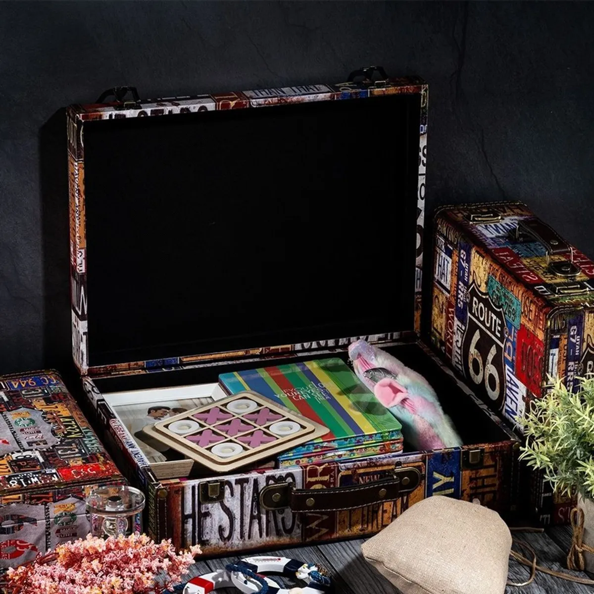 Open vintage storage box with black interior and assorted items inside
