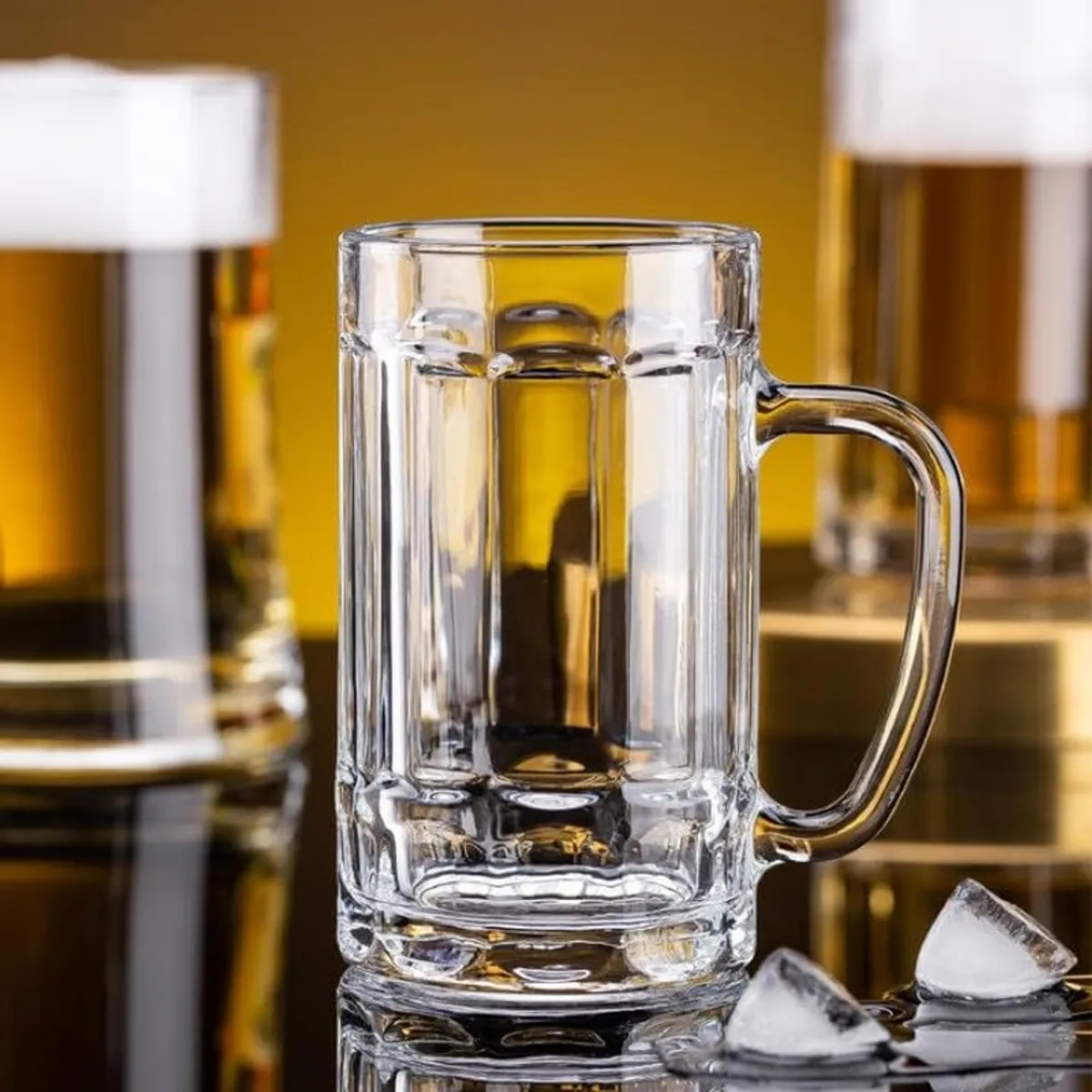 Clear cylindrical beer mug with a handle, displayed with bottles and ice