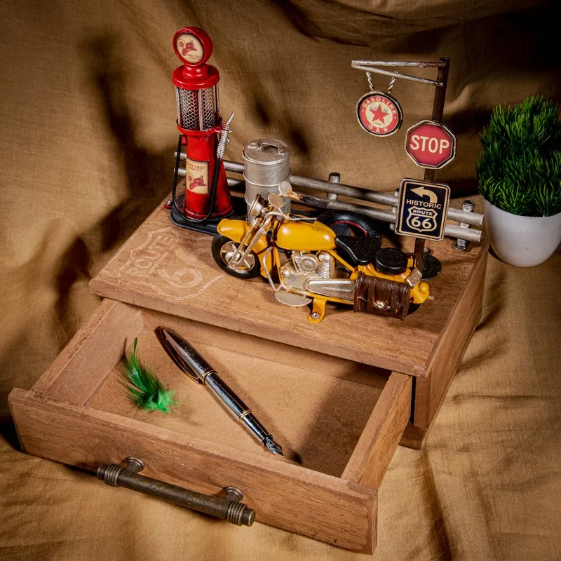 Open rustic wooden storage box showing a pen compartment and motorcycle décor