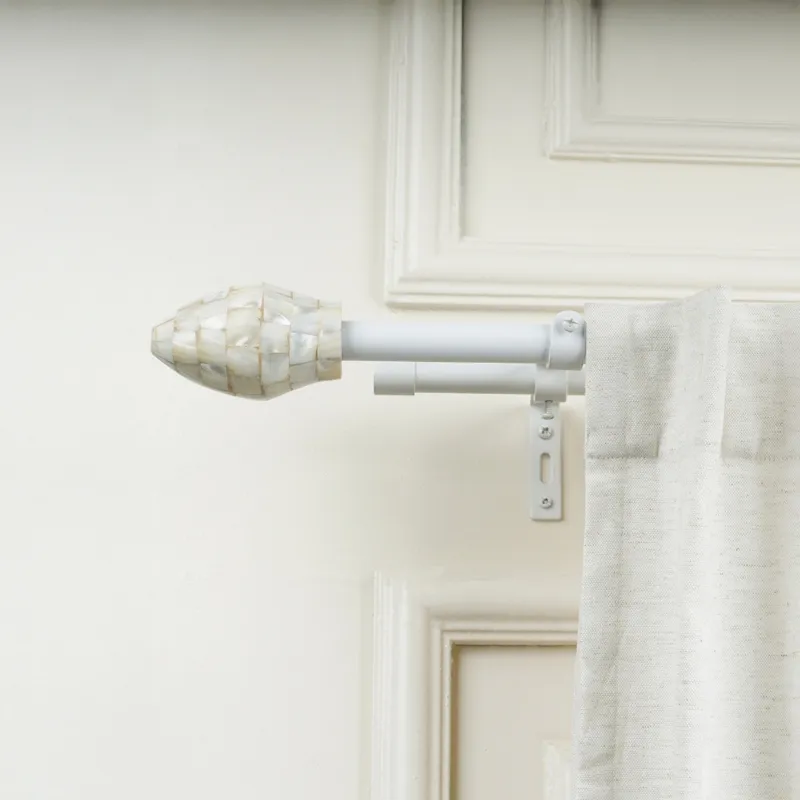 Ivory double curtain rod with oval finial and bracket beside a light curtain