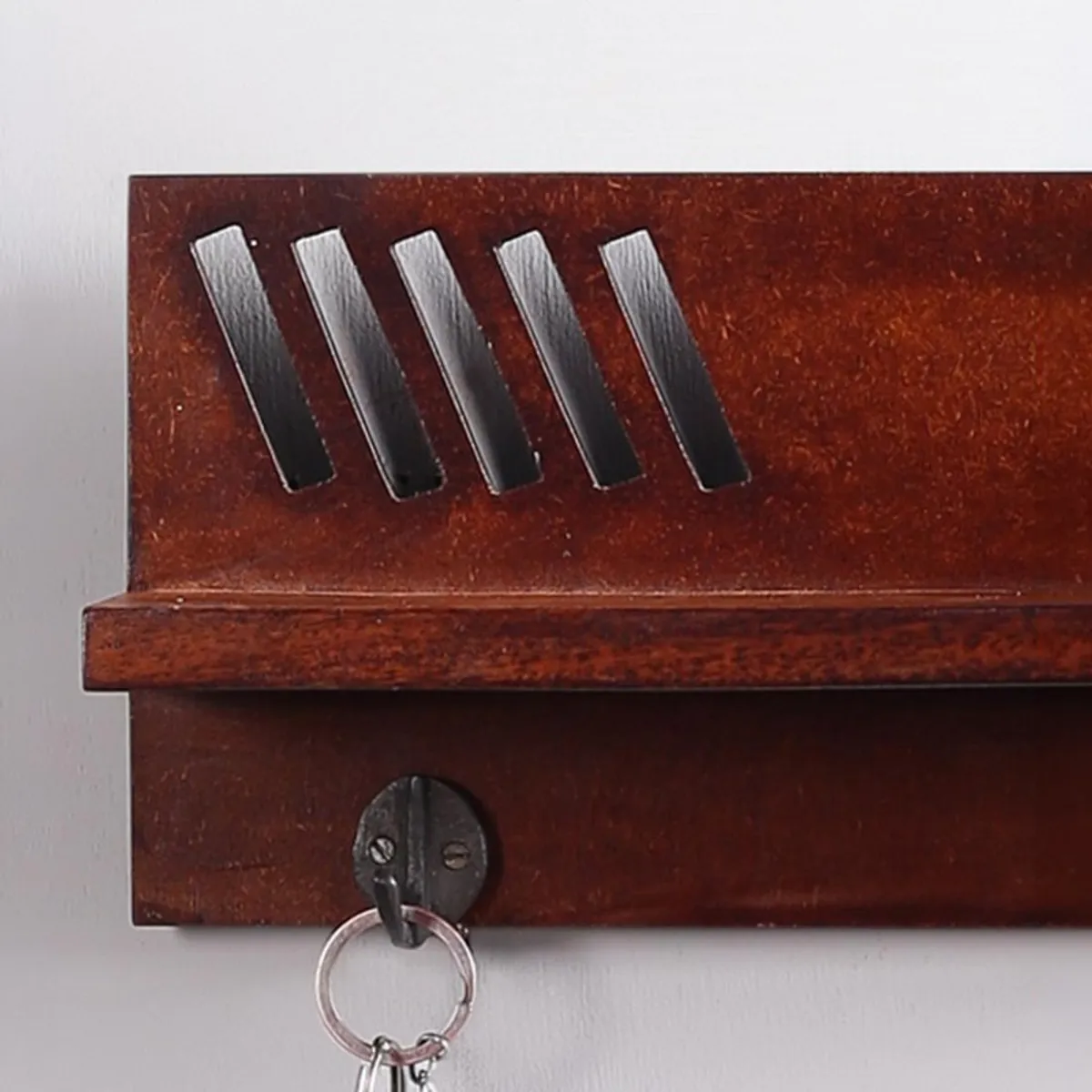 Close-up of brown wooden key holder shelf with metal hook
