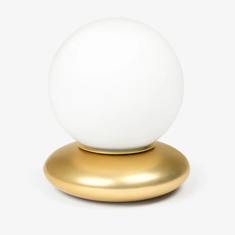 White spherical glass table lamp with rounded gold base