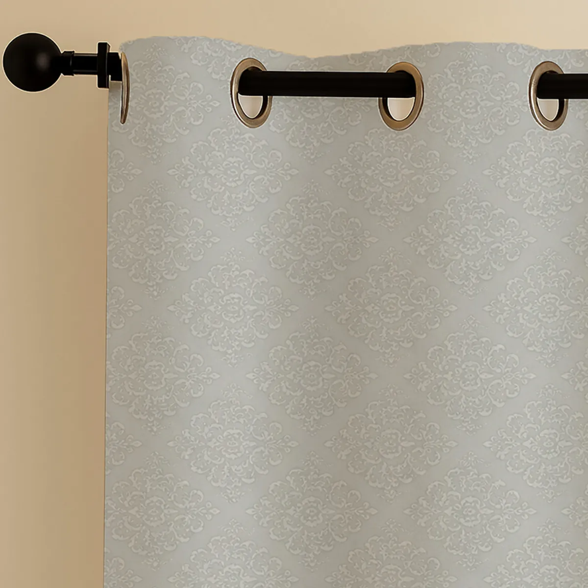 Close-up of grey curtain with eyelets and damask floral pattern