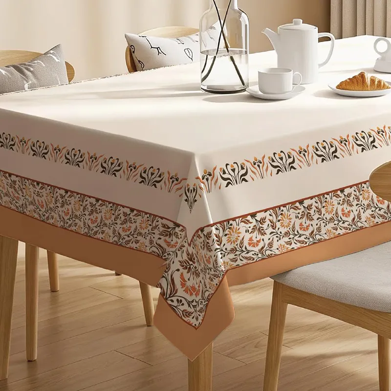 Close view of white printed table cover with floral border on dining table