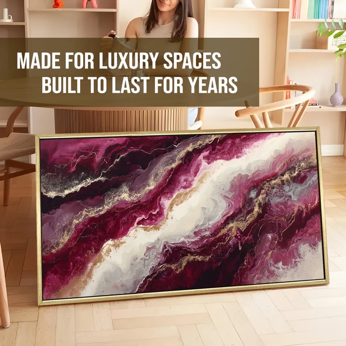 Framed abstract canvas painting in berry and gold tones leaning indoors