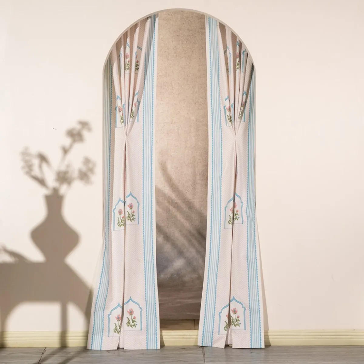 Pink and blue curtains framing a tall arched opening