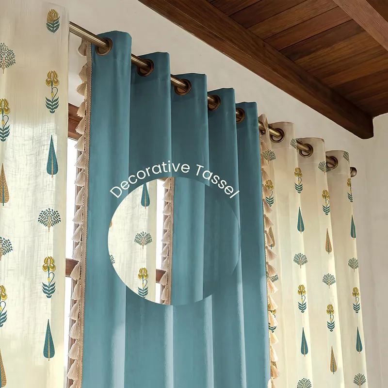 Close-up of blue and white curtains with eyelets and tasseled edge detail