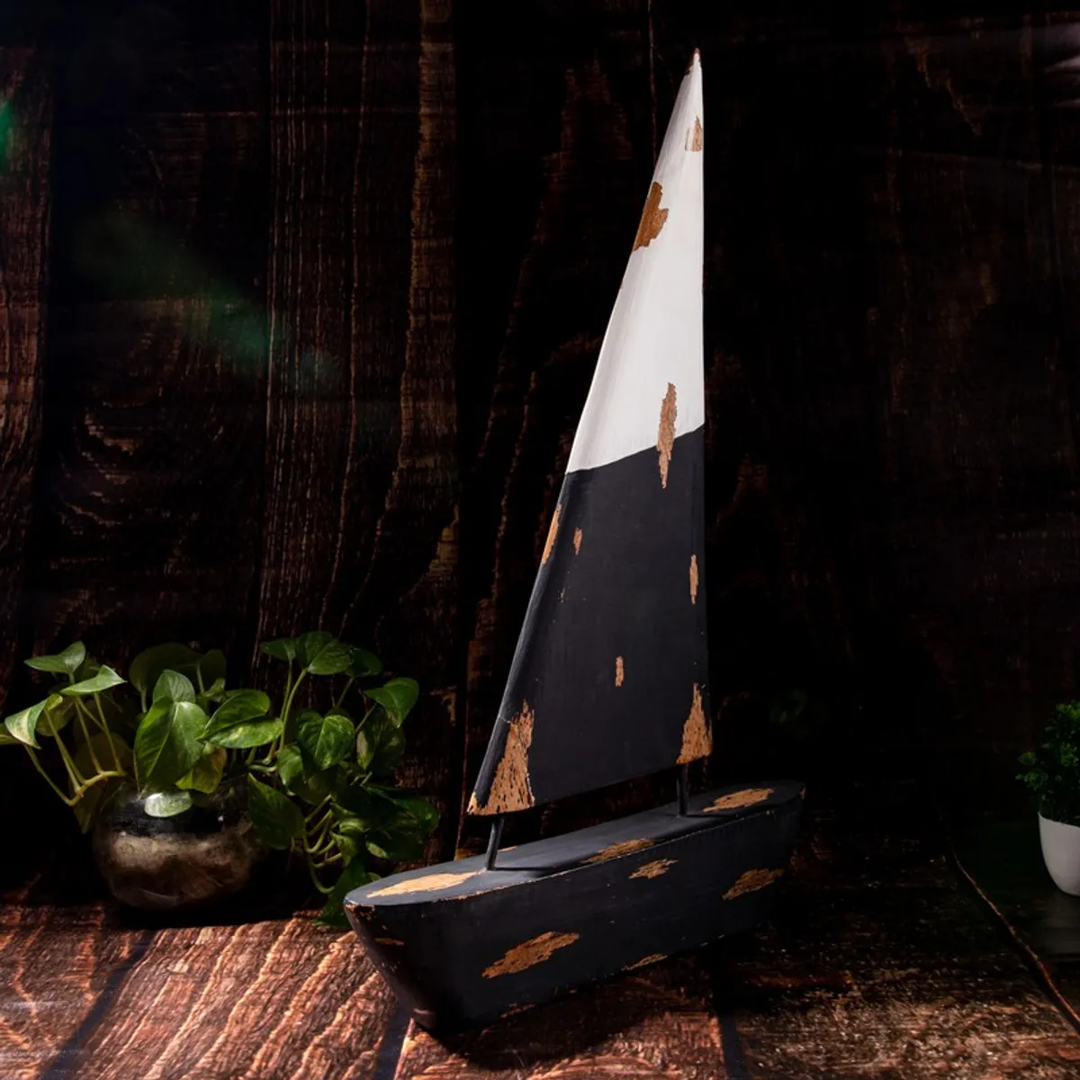 Black and white sailboat showpiece styled against a dark wood backdrop