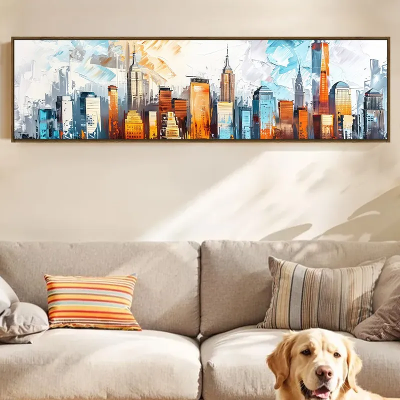 Framed skyline canvas displayed above a beige sofa with a dog resting below.