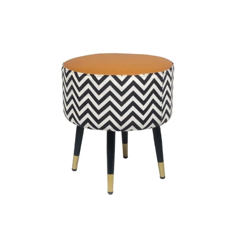 Angled view of the round chevron ottoman with black and gold-toned legs