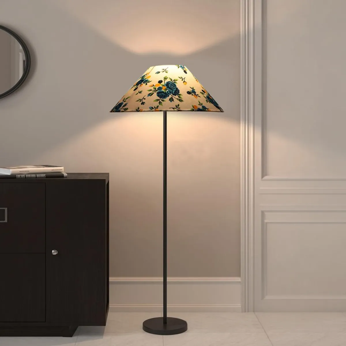 Blue floral floor lamp with warm glow beside a dark cabinet