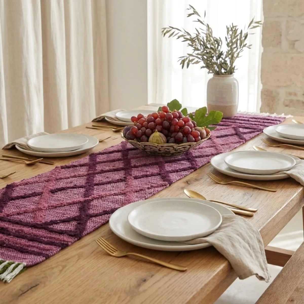 Purple textured table runner styled with crockery on a wooden dining table