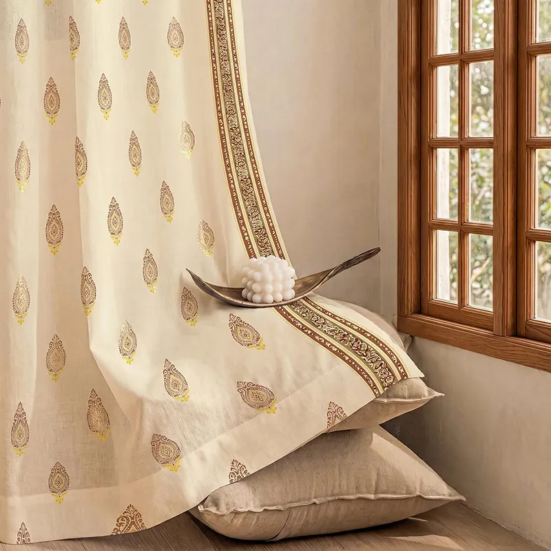 Foil printed curtain with buta motifs and decorative border beside a wooden window.