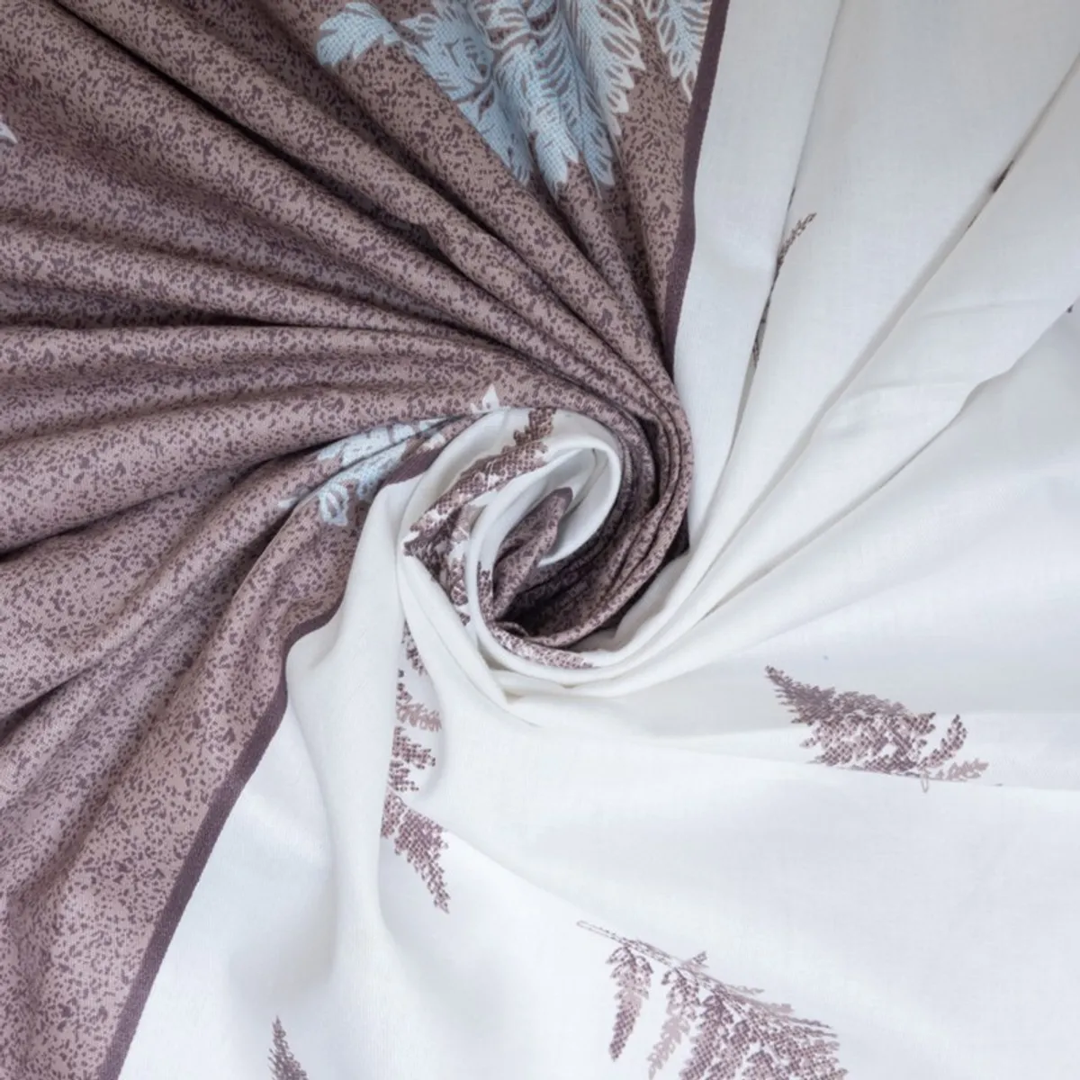 Close-up of purple and white printed cotton fabric with blue botanical motifs