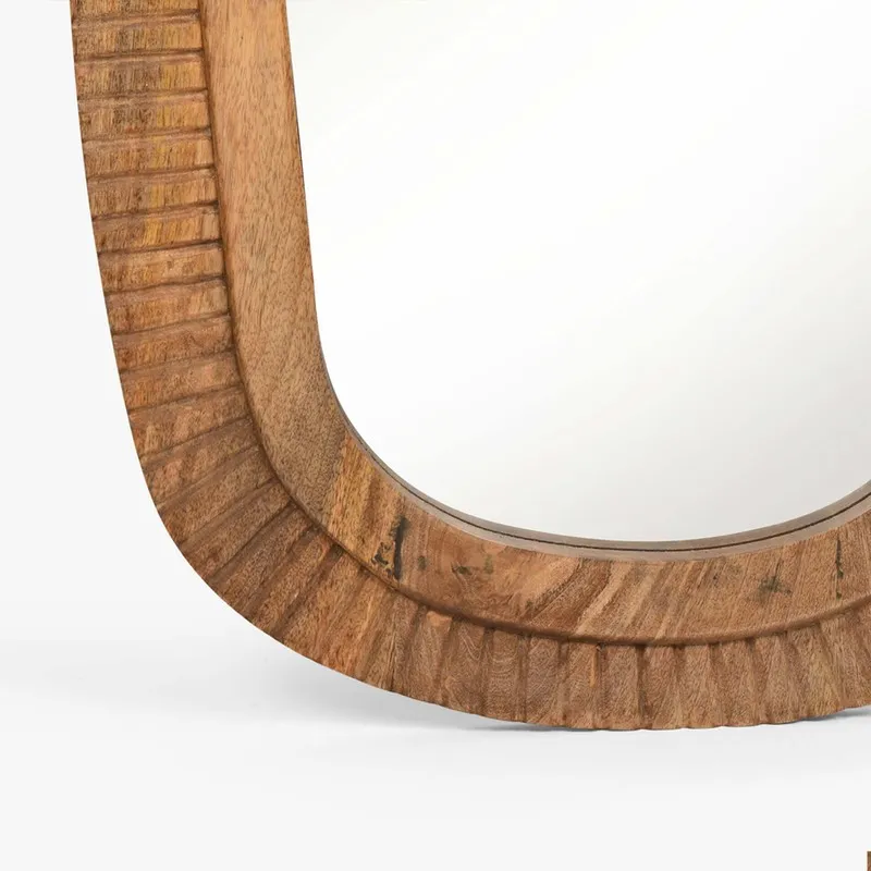 Close-up of the lower carved frame and mirror edge in mango wood