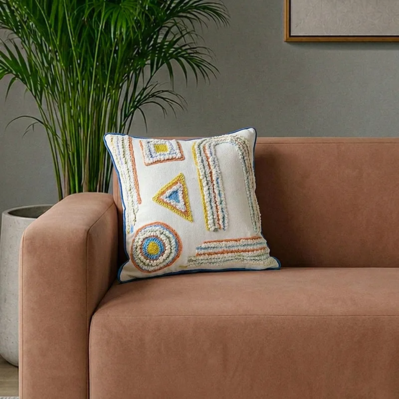 Square cushion cover with multicolour tufted geometric embroidery on a sofa
