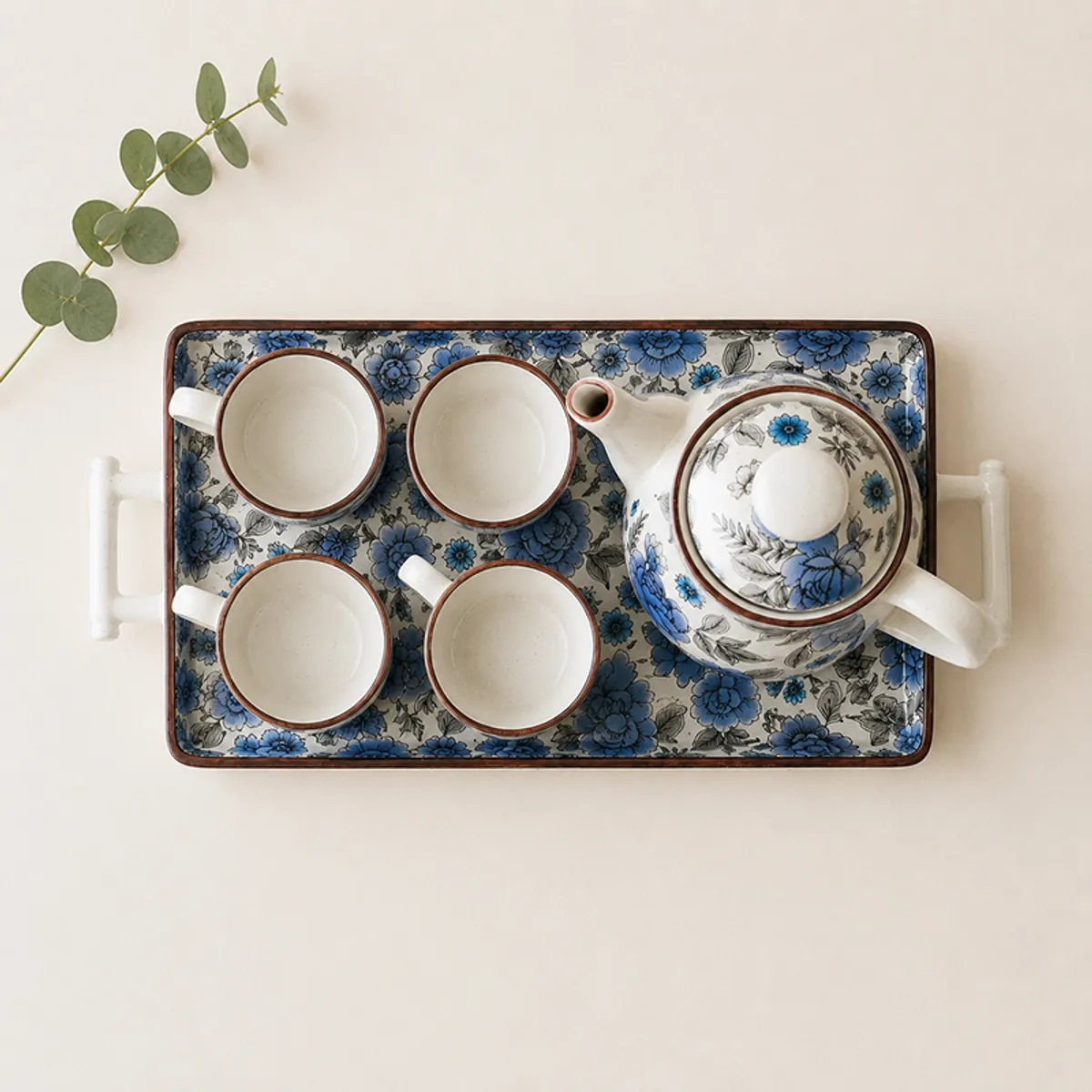 Top view showing four floral tea cups and a matching ceramic teapot
