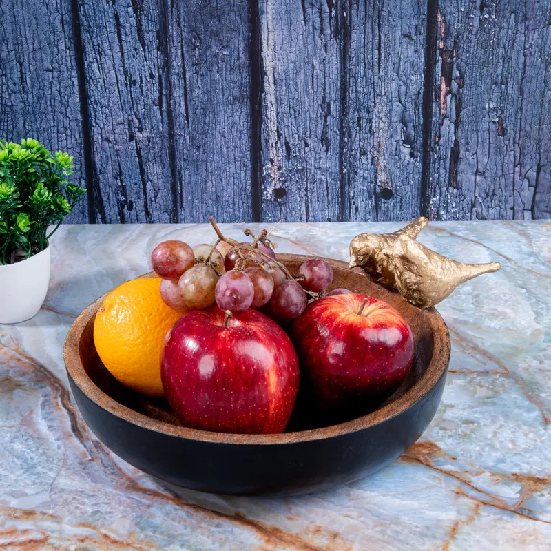 Wooden accent bowl displayed with fruit and a gold bird detail