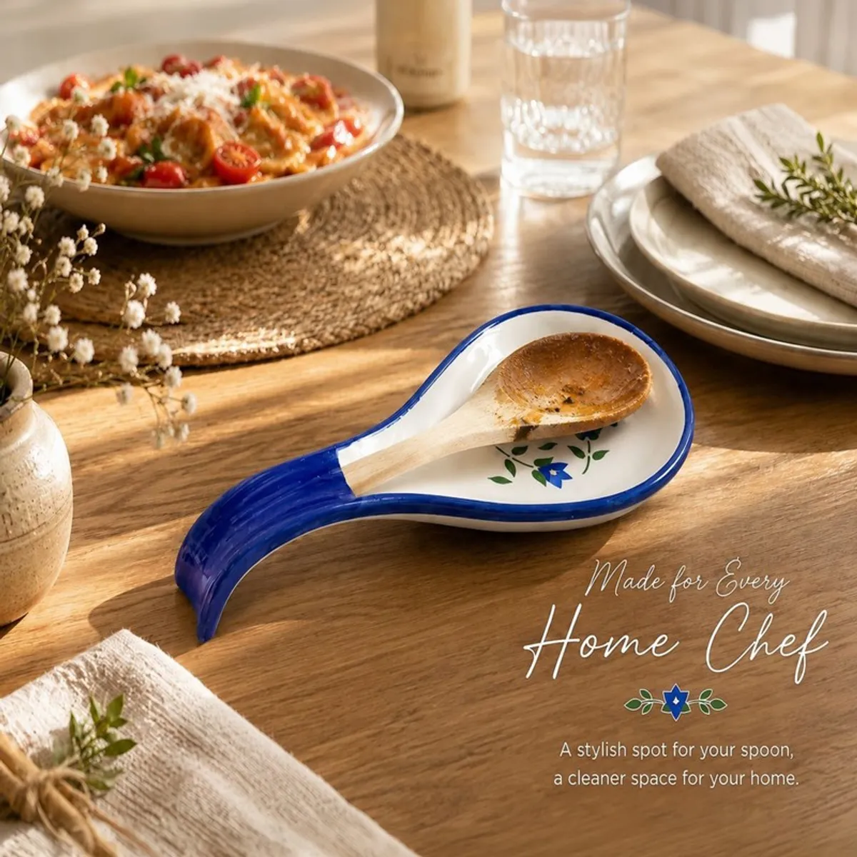 Blue ceramic spoon rest holding a wooden spoon on a dining table