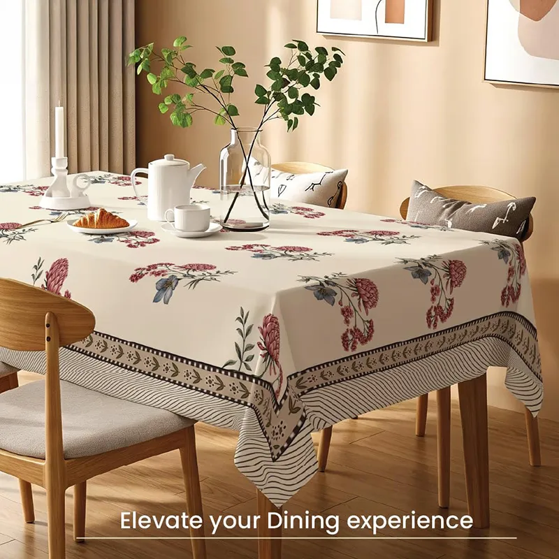 Dining table styled with a white floral printed table cover and bordered edges