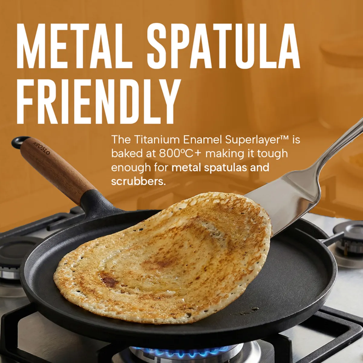 Black dosa tawa with a metal spatula lifting a browned dosa