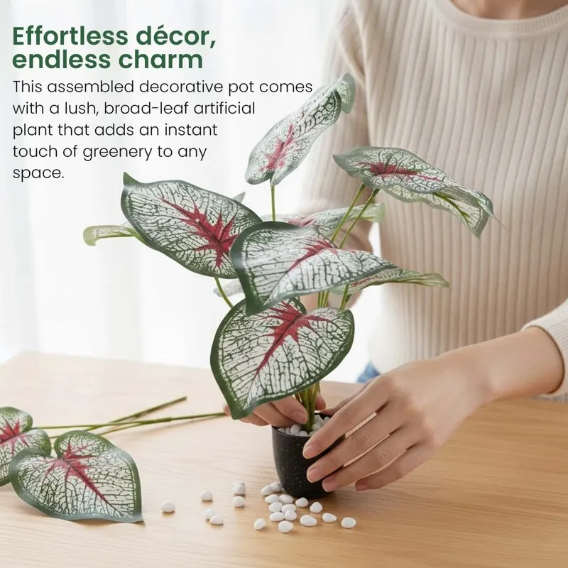 Artificial plant being arranged in a black pot with white pebbles