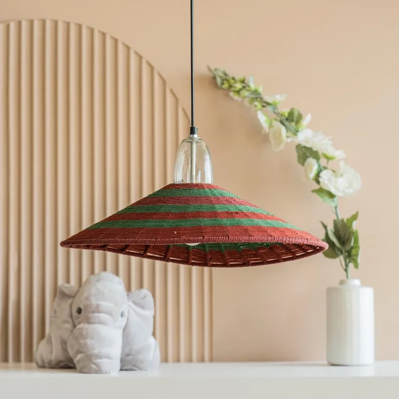 Red and green striped hanging lamp styled above a shelf with decor