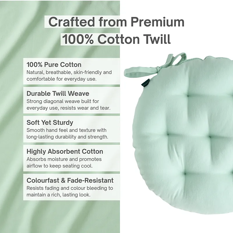 Close view of a sage green round chair pad with tufted detailing