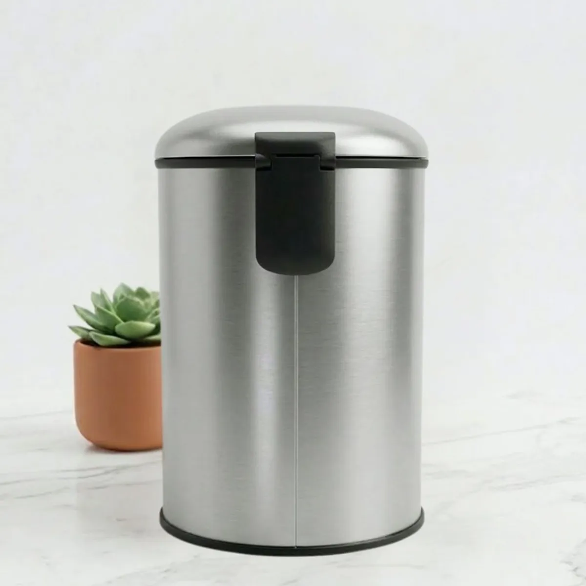 Rear view of a silver cylindrical dustbin with closed lid