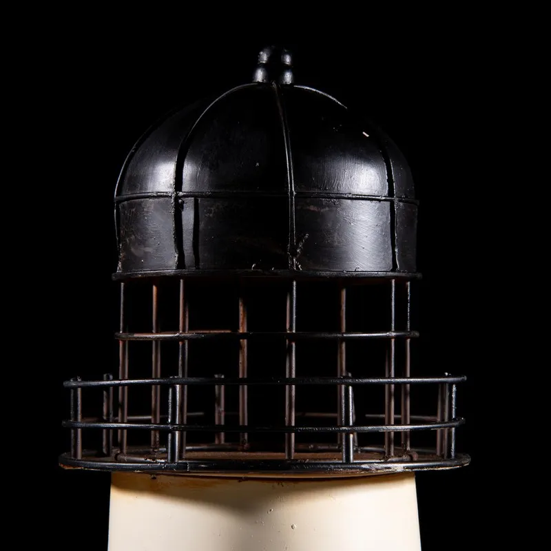 Close-up of the black domed top and railing detail of the lighthouse showpiece