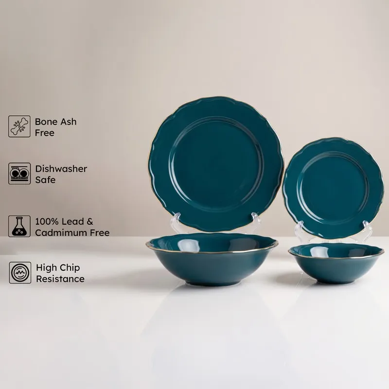 Dark teal plate and bowls with gold rims on display stands