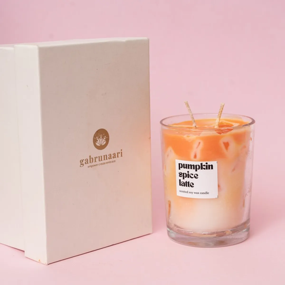 Orange-and-cream pumpkin spice soy wax candle in a clear glass jar