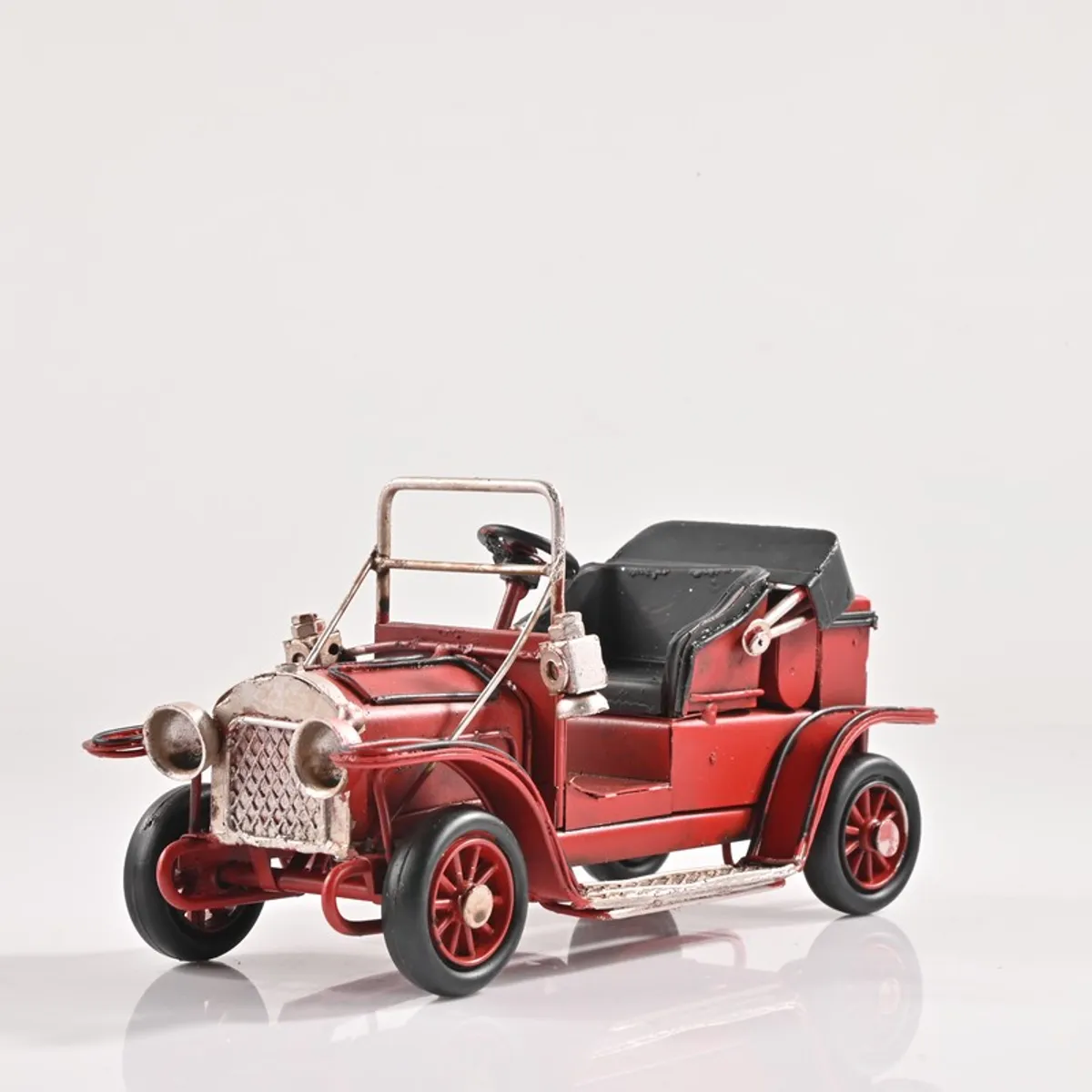 Red vintage car showpiece with black seat on a white background