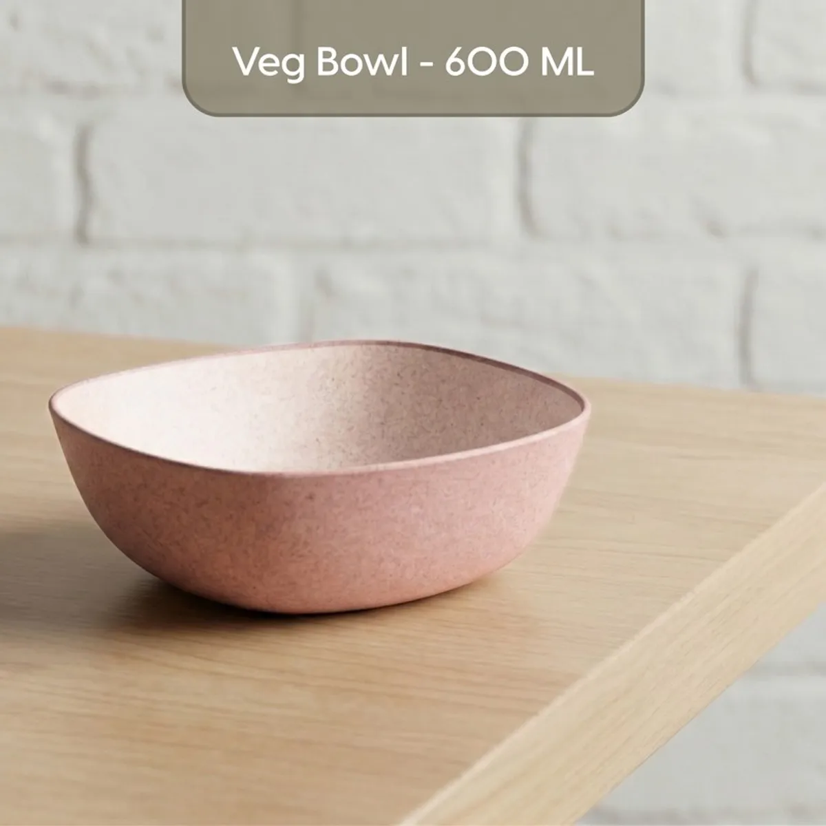 Pink square bowl with a speckled inner surface on a wooden shelf