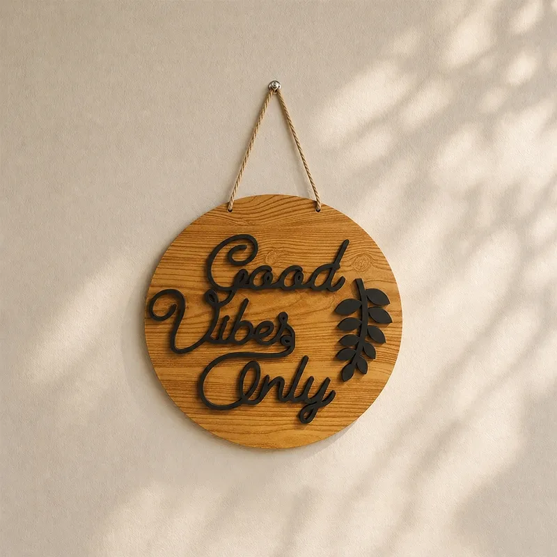 Round brown and black Good Vibes Only wall accent in soft sunlight