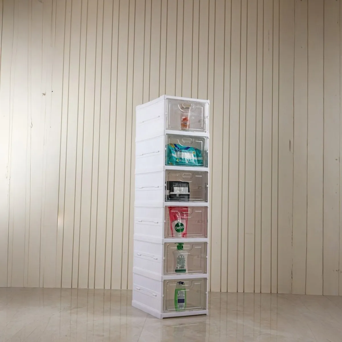 White six-tier rack with transparent compartments against a light panelled wall