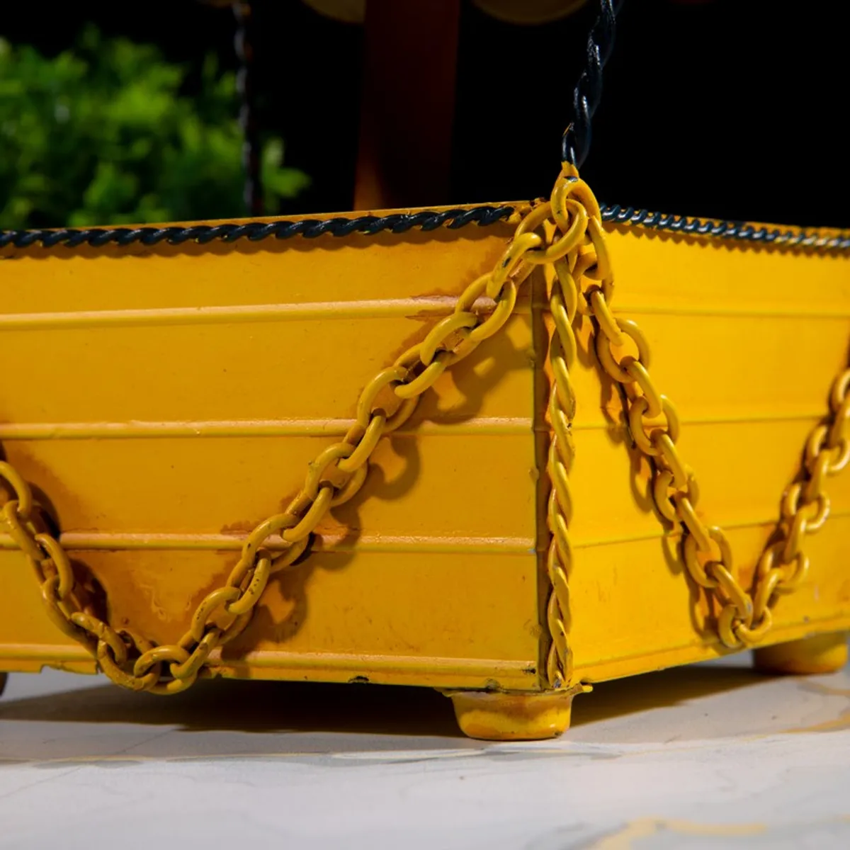 Detailed view of yellow basket corner with chain accents