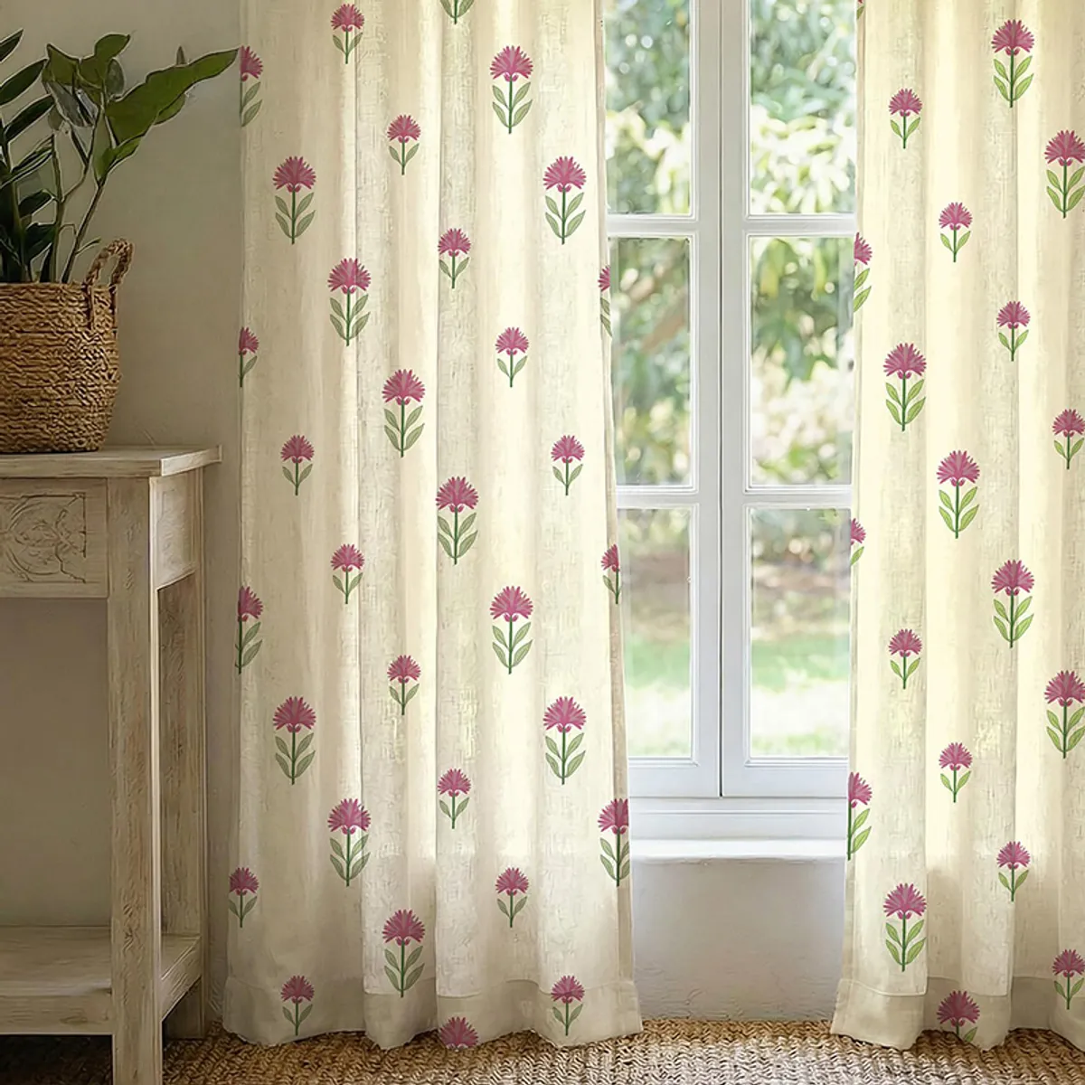 Pair of ivory floral curtains with pink and green motifs framing a window
