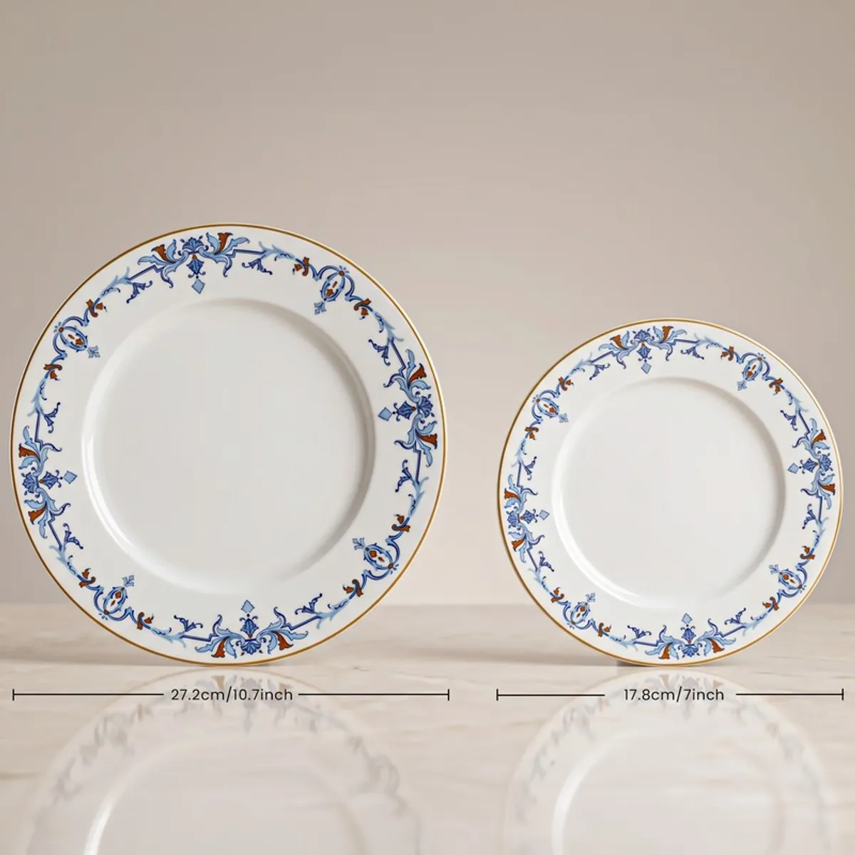 Large and small blue and white plates with floral vine border