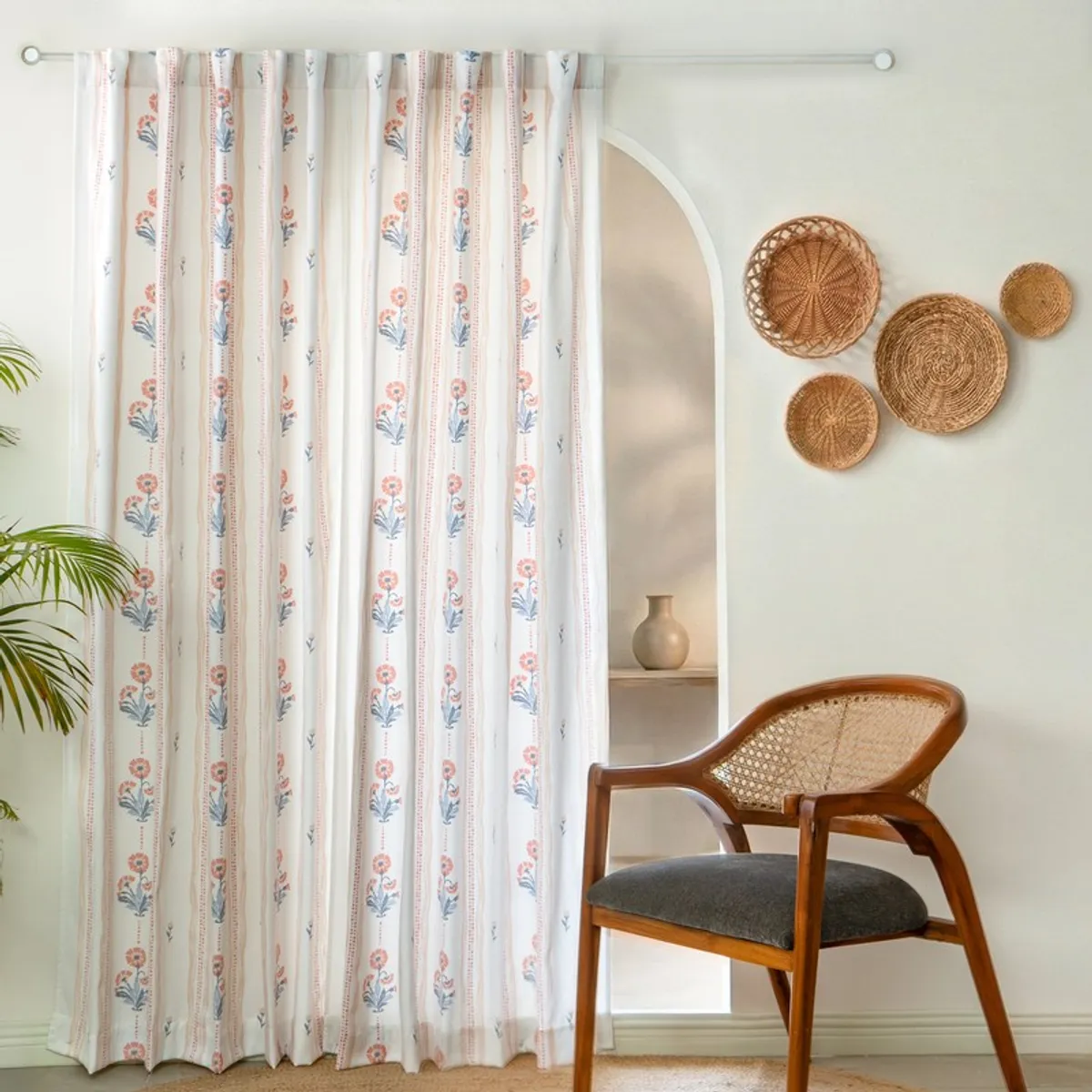 Pair of floral curtains hanging from a rod in a softly styled room