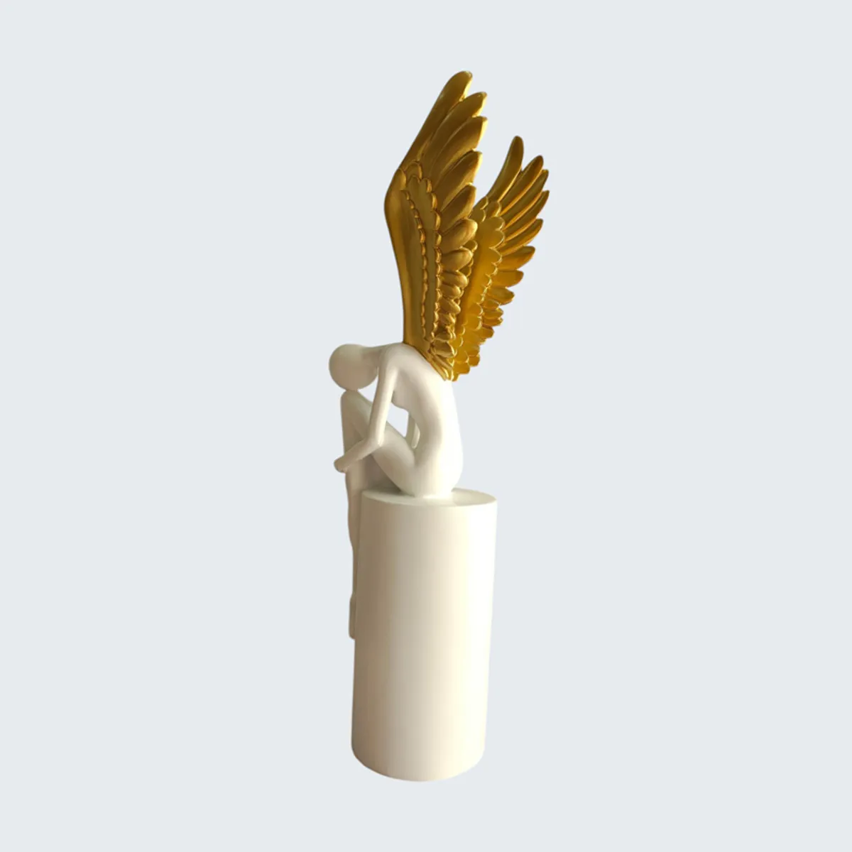 Side view of a white and gold winged abstract figurine on a cylindrical pedestal
