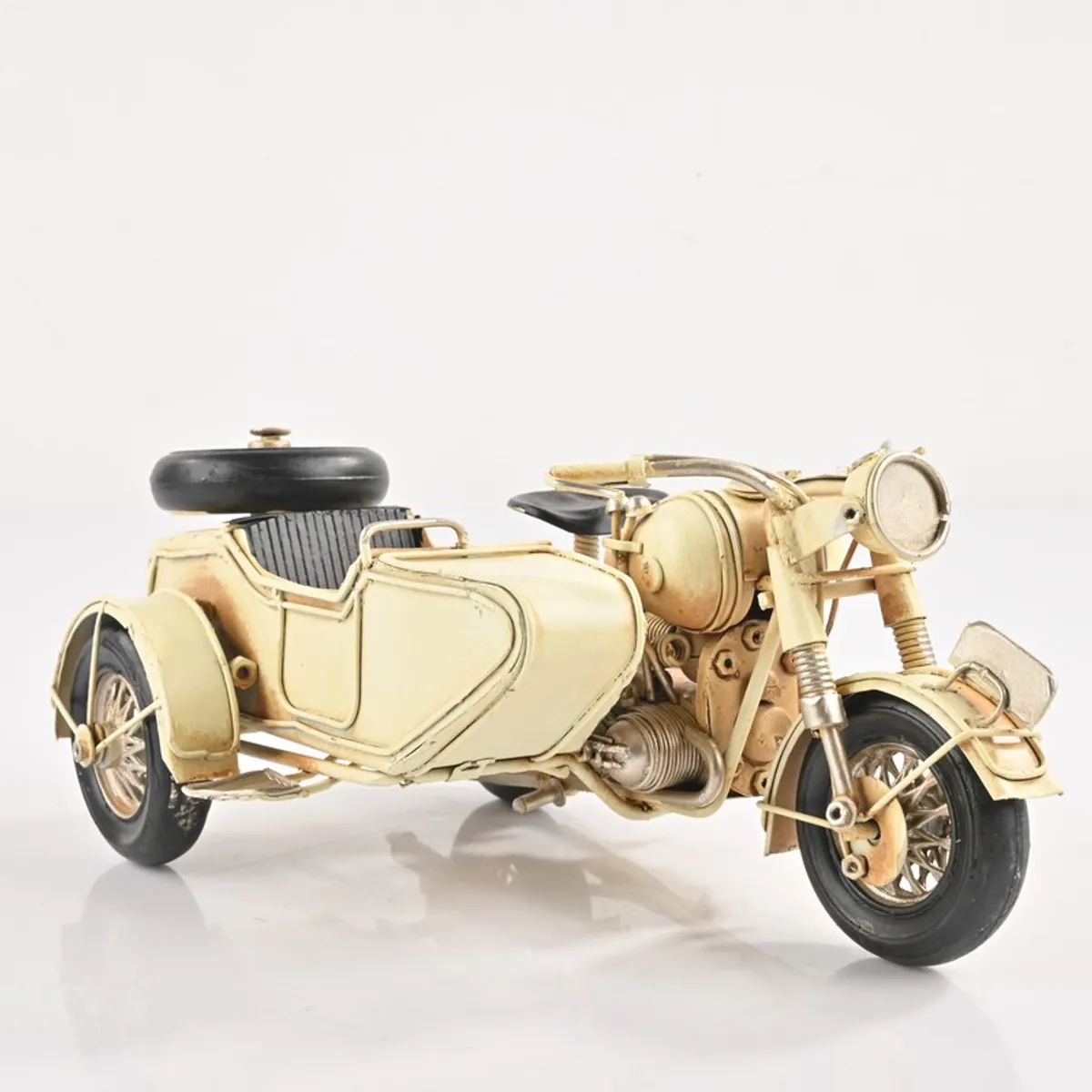 Studio view of gold-toned motorcycle sidecar showpiece