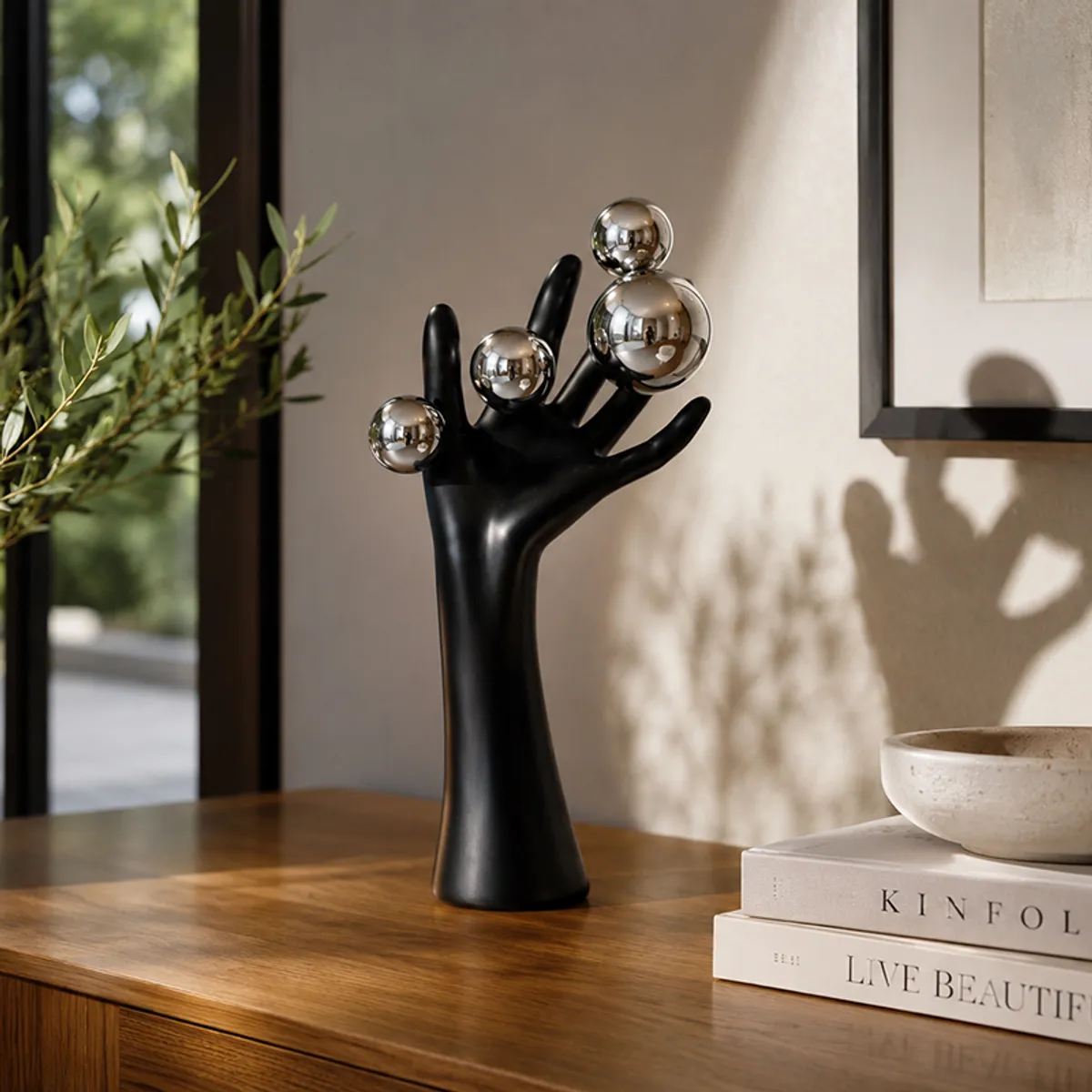 Black tabletop hand showpiece with silver accents on a wooden surface