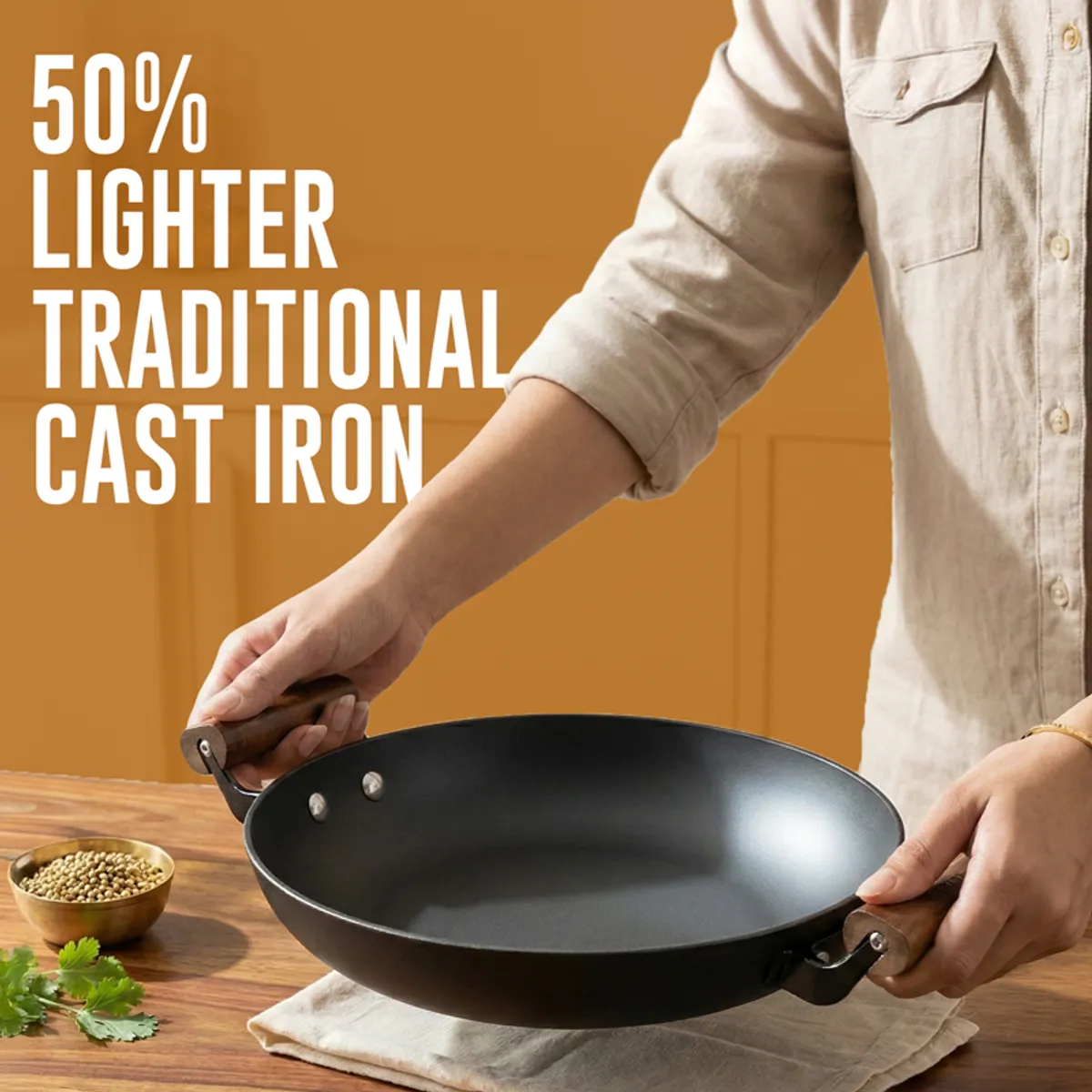 Person holding a black kadhai by its two side handles