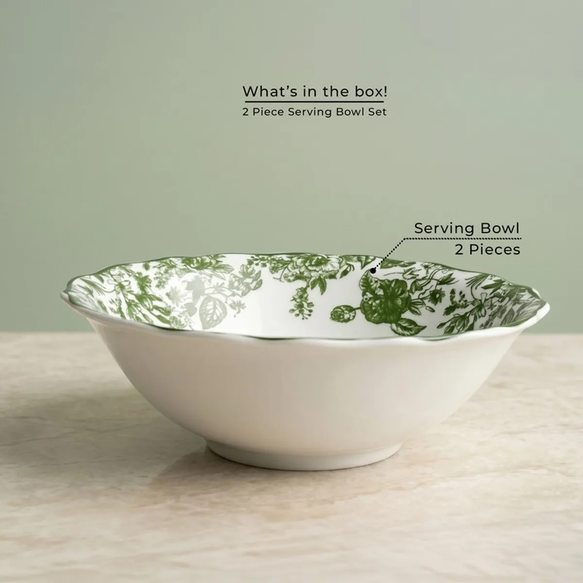 Single white serving bowl with green floral interior on a marble-look surface